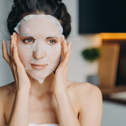 Una mujer colocandose una "Sheet Mask"